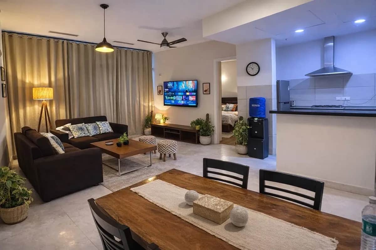 IREOグランドアーチ 3BHK オープンプランのリビング・ダイニング — ソファと6人掛けダイニングテーブル（グルガオン）
