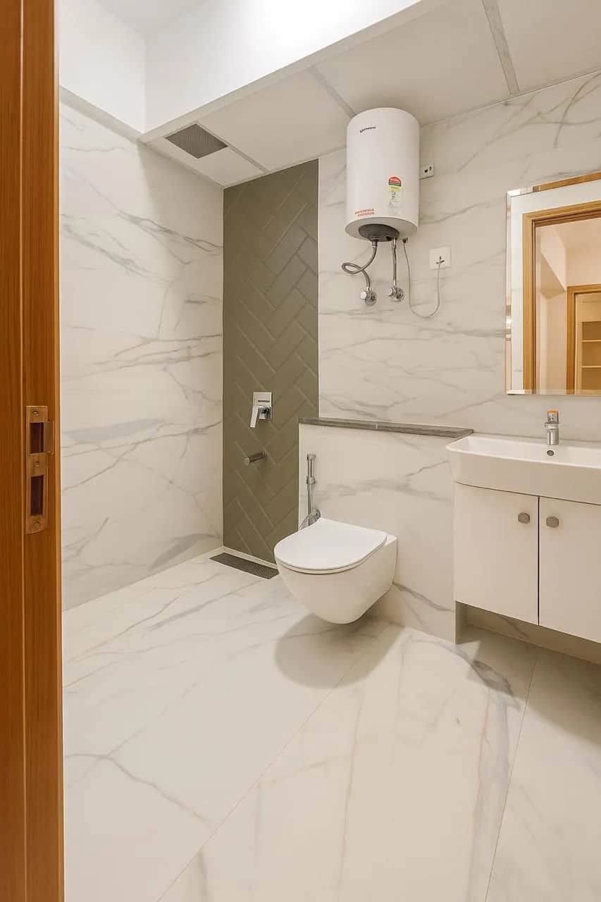 M3Mハイツ 2BHK マスターバスルーム — 大理石タイルとヘリンボーンシャワー壁（グルガオン）