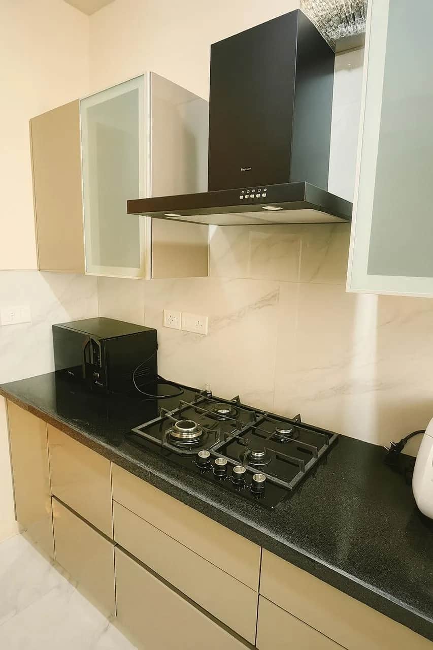 M3Mハイツ 2BHK モジュラーキッチン — 4口ガスコンロとブラック換気扇（グルガオン セクター65）